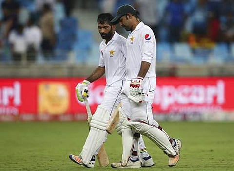Pakistan's Asad Shafiq and Sarfaraz Ahmed leave the field after the end of their fourth day Second Test cricket match against Sri Lanka in Dubai. | AP