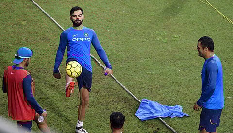 Skipper Virat Kohli and Mahendra Singh Dhoni playing football during a practice session at ACA Stadium in Guwahati on Monday ahead of 2nd T-20 match against Australia. | PTI