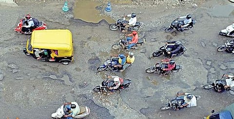 Motorists commute on a pothole-ridden road in Shanthinagar | JITHENDRA M