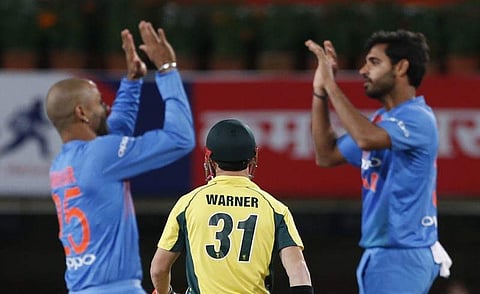 Australian cricketer David Warner walks back to the pavilion after being bowled out by India's Bhuvneshwar Kumar, right, during their first T20 cricket match in Ranchi, India, Saturday, Oct. 7, 2017. | AP