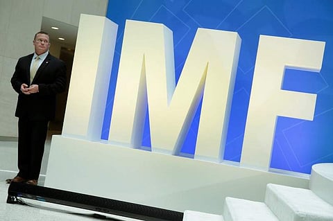 A security personnel stands next to International Monetary Fund logo at IMF headquarters in Washington. (Photo | Reuters)