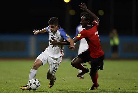 United States' Christian Pulisic, left, fight for the ball with Trinidad and Tobago's Nathan Lewis during a 2018 World Cup qualifying soccer match in Couv. | AP