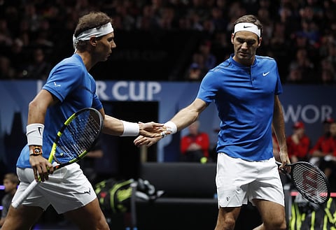Europe's Roger Federer, right, slap hands with his teammate Rafael Nadal, left, after winning a point against World's Jack Sock and Sam Querrey during their Laver Cup doubles tennis match in Prague. (AP)