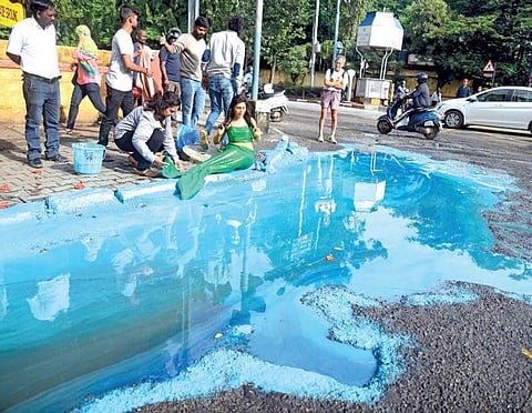 Actress Sonu Gowda dressed up as a mermaid performing for artist Baadal Nanjundaswamy’s art installation on potholes on Bengaluru roads | pushkar v