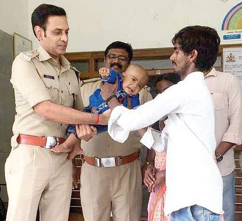 DCP (north-east) Girish S hands over the rescued one-year-old to his parents on Friday | Express
