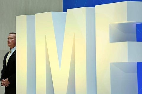 A security personnel stands next to International Monetary Fund logo at IMF headquarters. | Reuters