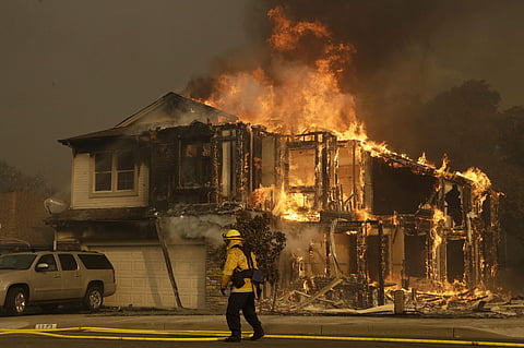 A firefighter walks near a flaming house in Santa Rosa, Calif. (Photo | AP)