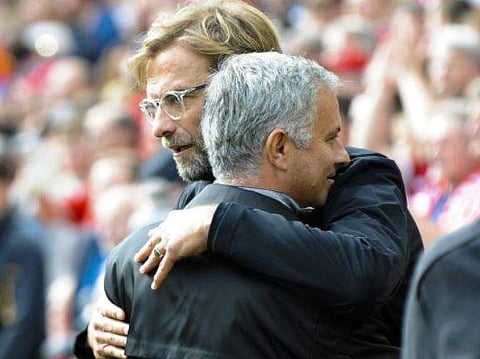 Liverpool coach Juergen Klopp, back, and Manchester United coach Jose Mourinho embrace each other prior to the EPL match. | AP