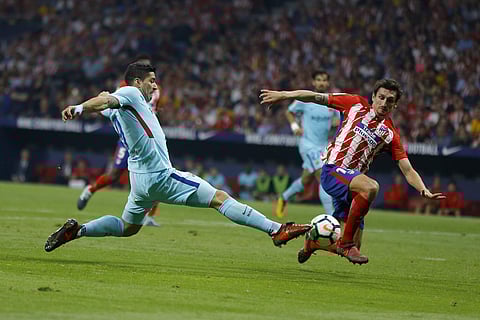 Barcelona's Luis Suarez, left, lunges for the ball against Atletico Madrid's Stefan Savic during a Spanish La Liga soccer match. | AP