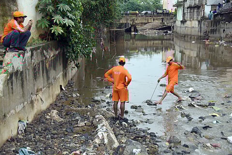 NDRF personal engaged in a resuce operation near a open drain where people were washed away in Bengaluru. (Nagaraja Gadekal | EPS)