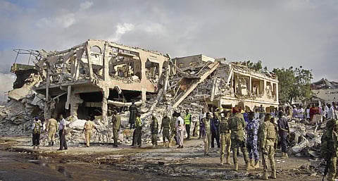 Somali security forces and others gather and search for bodies near destroyed buildings at the scene of Saturday's blast. (Photo | AP)
