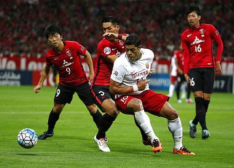 Shanghai SIPG's Hulk of Brazil, center right, and Urawa Reds' Tomoaki Makino, center left, vie for the ball in the second leg of their Asian Champions League semifinal. | AP