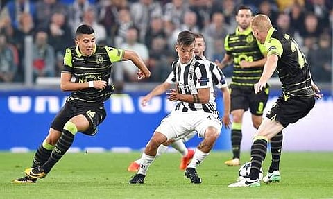 Juventus' Paulo Dybala, center, goes for the ball during the Champions League group D soccer match against Sporting. | AP