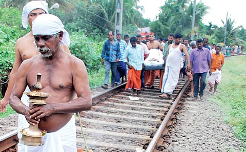 The funeral cortege of a man progresses with mourners carrying the body of the deceased down the rail tracks at Kammattipaadam near  Ernakulam South Station | k shijith