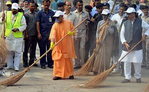 UP chief Minister Yogi Adityanath weilds a broom as he takes part in a cleanliness drive at the western gate of the Taj Mahal in Agra on Thursday. Dy Chief Minister Dinesh Sharma and Tourism Minister Rita Bahuguna are also seen. (PTI)
