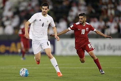 Iran's Saeid Ezatolahi (L) dribbles tha ball as Qatar's Hasan al-Haydos defends during the World Cup 2018 Asia qualifying football match between Qatar and Iran at the Jassim Bin Hamad stadium in Doha on March 23, 2017. | AFP