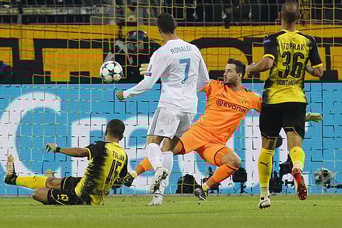 Real Madrid's Cristiano Ronaldo scores his side's second goal passing Dortmund goalkeeper Roman Buerki, in orange, during a Champions League Group H soccer match between Borussia Dortmund and Real Madrid. | AP
