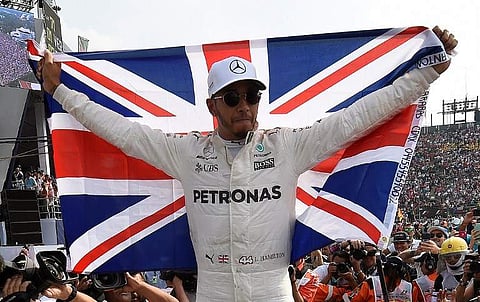 Mercedes' British driver Lewis Hamilton celebrates after winning his fourth Formula One world title despite finishing the Mexican Grand Prix in ninth place, at the Hermanos Rodriguez circuit in Mexico City. | AFP