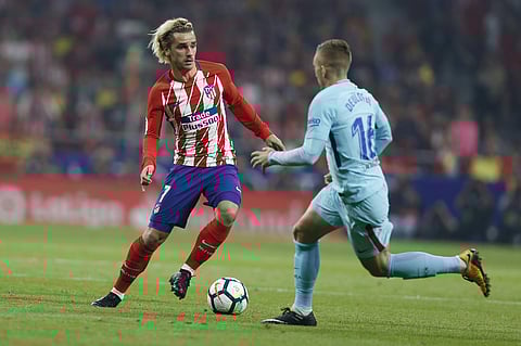 Atletico Madrid's Antoine Griezmann, left, tussles for the ball with Barcelona's Gerard Deulofeu during a Spanish La Liga soccer match against Barcelona. | AP