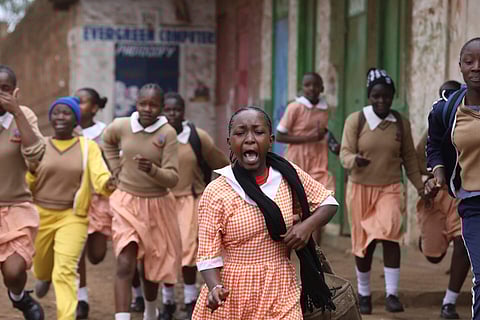 School students run for safety between police and protestors during clashes between protestors and police in the Kawangware suburb of Nairobi, Kenya, on Monday. (Photo | AP)