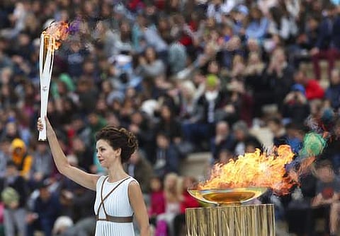 Actress Katerina Lehou playing the role of high priestess holds an Olympic torch during a handover ceremony for the Olympic Flame at Panathenaic stadium in Athens.|AP