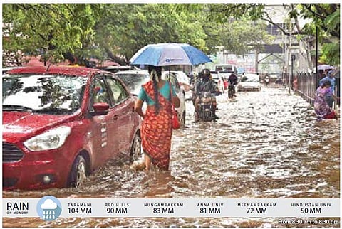 A woman wades through a flooded road near Thirumangalam in Chennai on Monday | P Jawahar