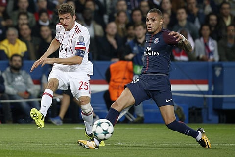 Bayern's Thomas Mueller, left, and PSG's Layvin Kurzawa challenge for the ball during the Champions League Group B soccer match between Paris Saint-Germain and Bayern Munich in Paris. | AP