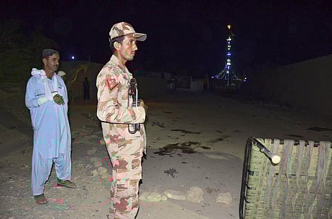 Pakistani security personnel stand guard at the site of a blast in Jhal Magsi. (Photo | AP)