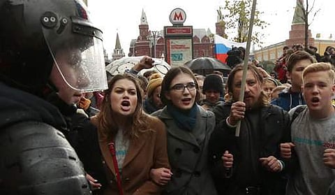 Riot police officers block protesters with Russian flags during a rally in Moscow, Russia, Saturday, Oct. 7, 2017. Opposition leader Alexei Navalny has worked to organize protests in support of his presidential bid across Russia on Saturday, President Vla
