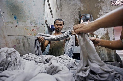 Workers dye fabrics inside a dye factory at an industrial area in Mumbai. (Photo | Reuters)