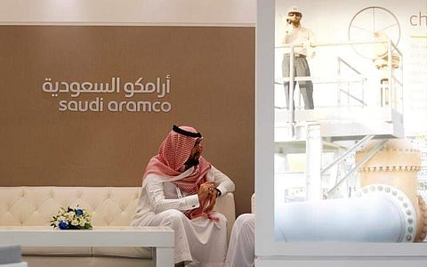 A Saudi Aramco employee sits in the area of its stand at the Middle East Petrotech 2016 in Manama, Bahrain. (File photo | Reuters)