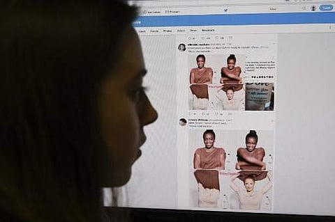 A posed picture taken in London on October 9, 2017 shows a journalist looking at screenshots retweeted by Twitter users on the social networking site of a video-clip used in an online advert by the personal care brand Dove. (Photo | AFP)