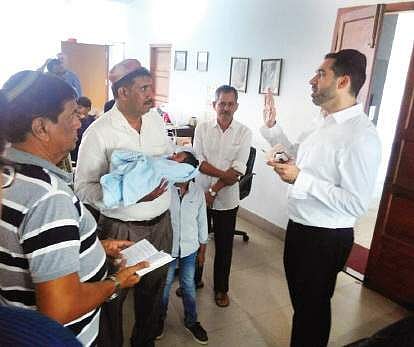Mordokkayi Safir with his baby boy listens to the prayers said by Jewish rabbi Avive Mizrakhi