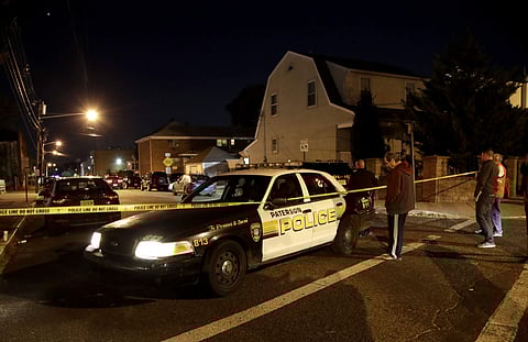 A police cruiser stands at the corner of Getty Avenue and Genessee Avenue as officials inspect a home. (Photo | AP)