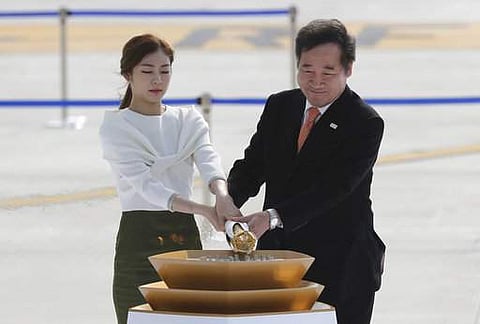 South Korean Prime Minister Lee Nak-yon, right, and former South Korean Olympic figure skating champion Yuna Kim, light the cauldron with the Olympic Flame during the Olympic Flame Arrival ceremony at Incheon International Airport in Incheon. | AP