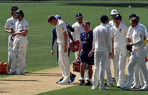 England's paceman Jake Ball (C) leaves the ground after injuring himself while bowling to Cricket Australia XI batsman Jake Carder on the second day of a four-day Ashes tour match at Adelaide Oval in Adelaide on November 9, 2017. | AFP