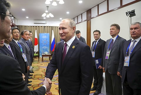 Russia's President Vladimir Putin, center, greets members of Japan's Prime Minister Shinzo Abe's delegation prior to the talks at the APEC Business Advisory Council  | AP