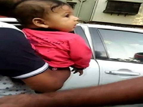 The recent video shot on a mobile phone shows that the seven-month-old baby was not inside the car but in the arms of another family member when the Mumbai Traffic Police warned to tow it away. (Photo | ANI Twitter)