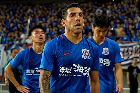This file picture taken on September 16, 2017 shows Shanghai Shenhua's Carlos Tevez walking to the stands after losing the 2017 Chinese Super League football match between Shanghai East Asia (SIPG) FC and Shanghai Shenhua. | AFP