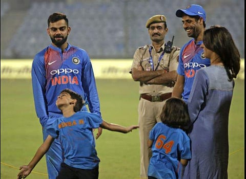 Indian cricket captain Virat Kohli, left, watches Ashish Nehra's son mimic the bowling action of his father, right, at the end of Nehra's last international match in New Delhi | AP