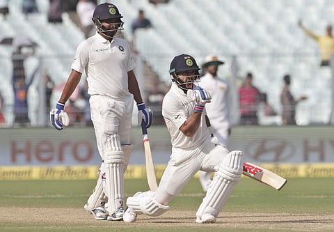 India's Mohammed Shami, left, watches captain Virat Kohli celebrate scoring a century | AP