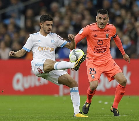 Marseille's Morgan Sanson, left, challenges for the ball with Caen's Julien Feret during the League One soccer match. | AP