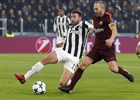 Juventus' Andrea Barzagli, left, challenges Barcelona's Andres Iniesta during the Champions League group D soccer match between Juventus and Barcelona, at the Allianz Stadium in Turin. | AP