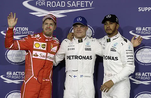 Valtteri Bottas (C) celebrates his pole position with second placed Lewis Hamilton (R) and third placed Sebastian Vettel | AP