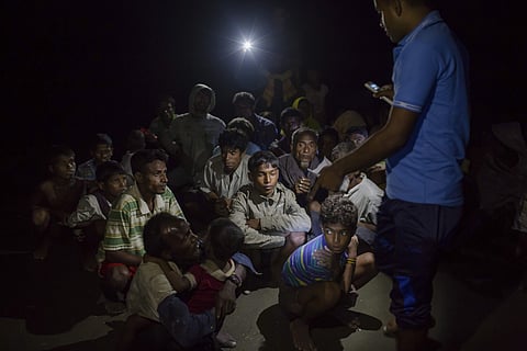 In this Nov. 10, 2017 photo, a Bangladeshi Border Guard, right, counts a group of newly arrived Rohingya Muslims near Shah Porir Dwip, Bangladesh. (AP Photo)