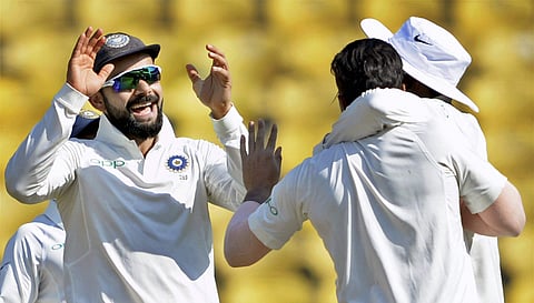 Indian captain Virat Kohli along with teammates celebrates the wicket of Sri Lankan batsman Lahiru Thirimanne during the second Test match played in Nagpur on Monday. | PTI