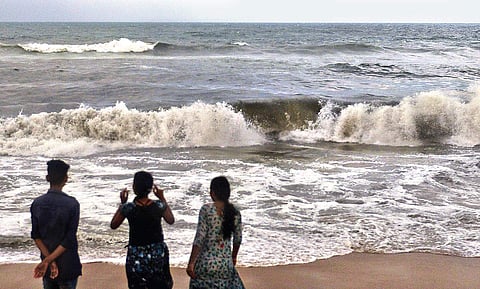 Some college students were surprised by the black colour of the sea at Marina, and looked reluctant to play in the water | D SAMPATHKUMAR