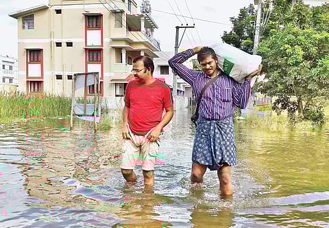 Residents wade through floodwater at Sunnambu Kolathur on Sunday | Samuel Merigala