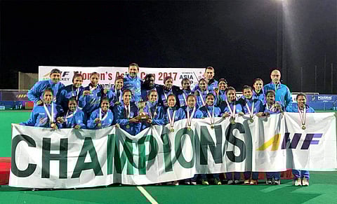 Indian women's hockey team members pose with medals and trophy as they celebrate after beating China to win women's Asia Cup hockey title on Sunday. | PTI