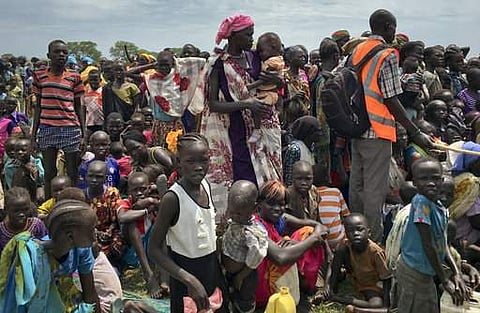 FILE - In this Saturday, June 17, 2017 file photo, men, women and children line up to be registered with the World Food Programme (WFP) for food distribution in Old Fangak, in Jonglei state, South Sudan. | AP